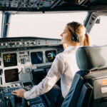 Woman,Pilot,Sitting,In,Airplane,Cockpit,,Wearing,Headset.