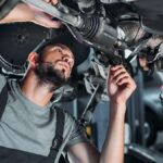 mechanic-in-overalls-repairing-car-in-auto-repair-2021-08-29-22-51-18-utc-1-1080×675-1